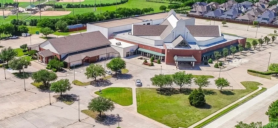 BASIS Plano campus seen from above, surrounded by trees and neighbouring homes