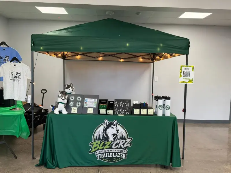 The green pop-up shop stall strung with fairy lights, husky plushes, magnets and water bottles laid out on the counter