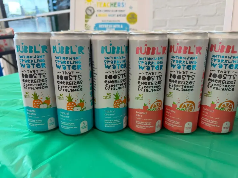 A close-up row of Bubbl’r antioxidant sparkling water cans in tropical dream’r and twisted elix’r flavours