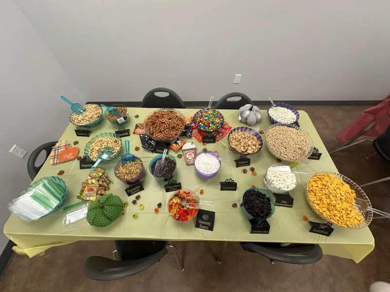 The trail-mix bar seen from above, a dozen labelled bowls and a stack of bags ready for teachers to fill